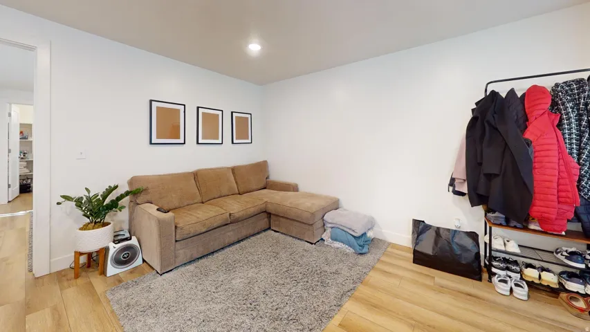 Recessed lighting, light wood-finish flooring, and white walls