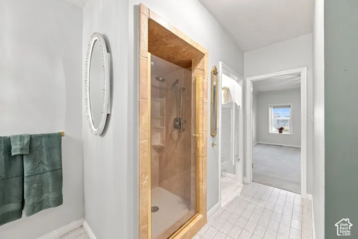 Tiled walk-in shower with glass enclosure and built-in shelving