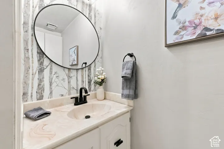 Built-in vanity with a single basin, matte black faucet, and round mirror