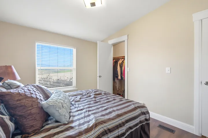 White window casing, recessed closet, wood-finish flooring, and a flush-mount ceiling light fixture