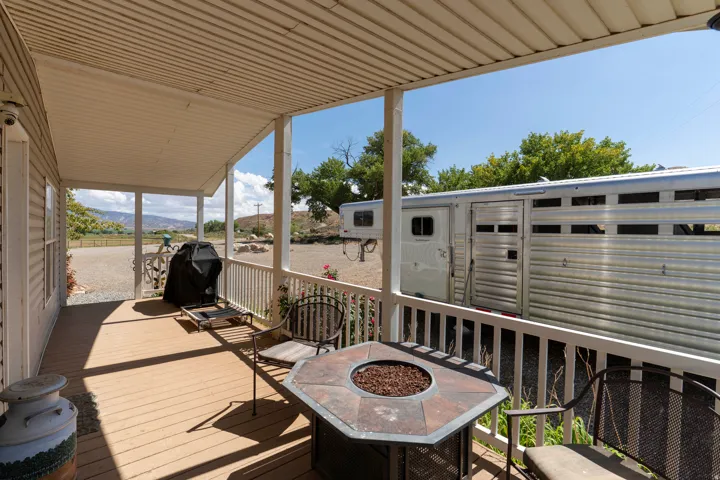 Covered porch with wood-finish decking and white railing