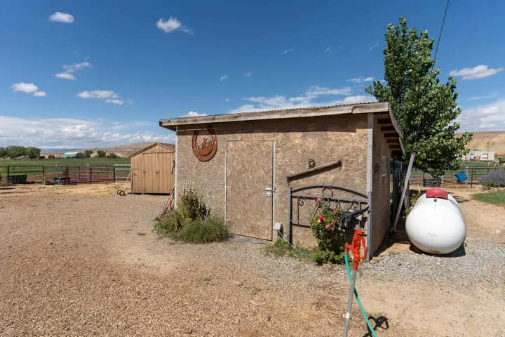 Gravel surface surrounding two wood-paneled sheds
