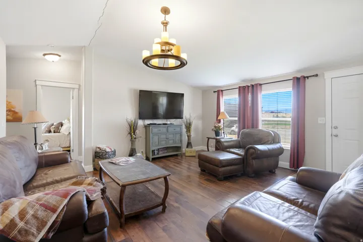 Wood-finish flooring throughout, multiple windows, recessed lighting, and a detailed chandelier