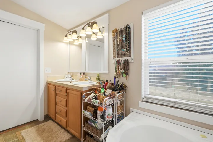 Double vanity with individual sinks, integrated countertop, and warm wood-finish cabinetry
