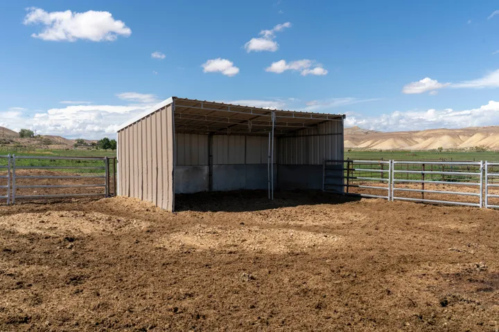 Metal-roof shelter with panel siding, supported by metal posts, and surrounded by sturdy metal fencing