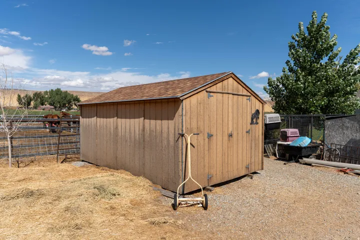 Wood-sided shed with shingle roof