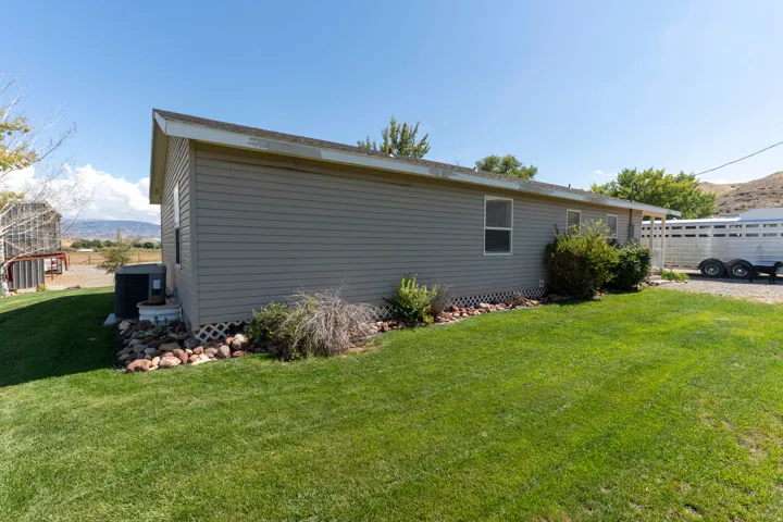 Gray horizontal siding with multiple windows and a grass lawn