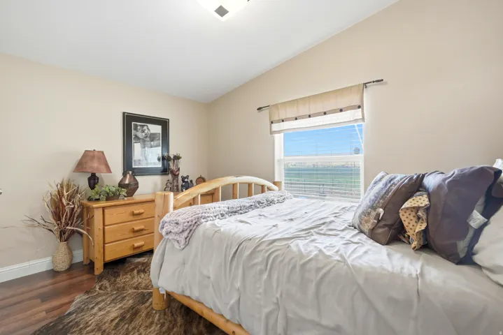 Vaulted ceiling, wood-finish flooring, single window with blinds, recessed lighting fixture