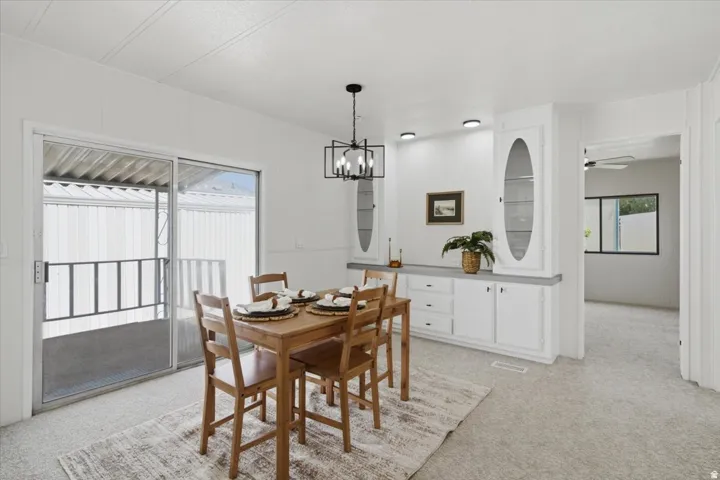 Sliding glass doors, built-in cabinetry with glass display doors, recessed lighting, and an open entryway