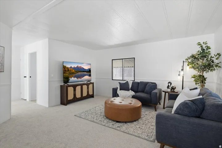 Carpeted flooring, white walls, and a multi-pane window with a patterned privacy screen