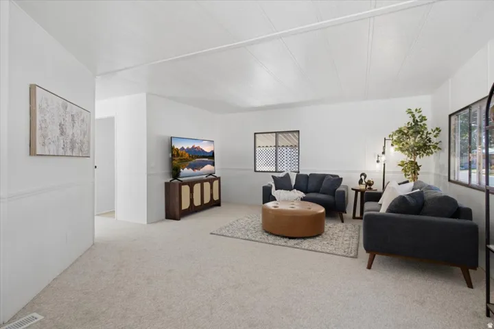 Carpeted flooring, white walls, white ceiling, and window with grid pattern
