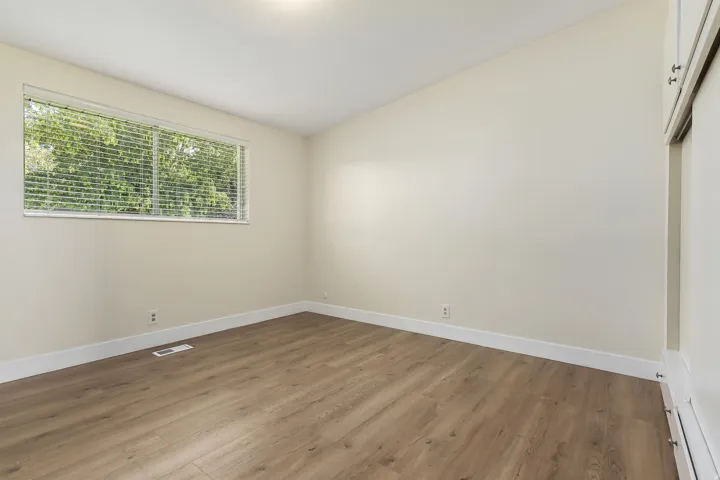 Recessed ceiling lighting, wood-finish flooring, and a window with blinds