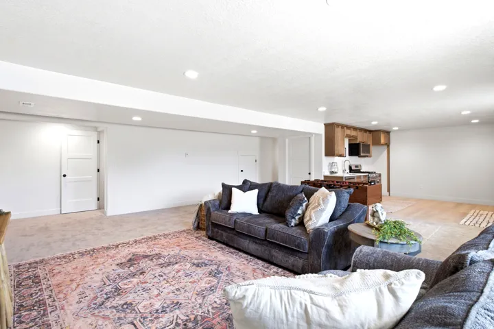 Recessed ceiling lighting, wood-finish flooring, built-in cabinetry, stainless steel sink, and stainless steel microwave