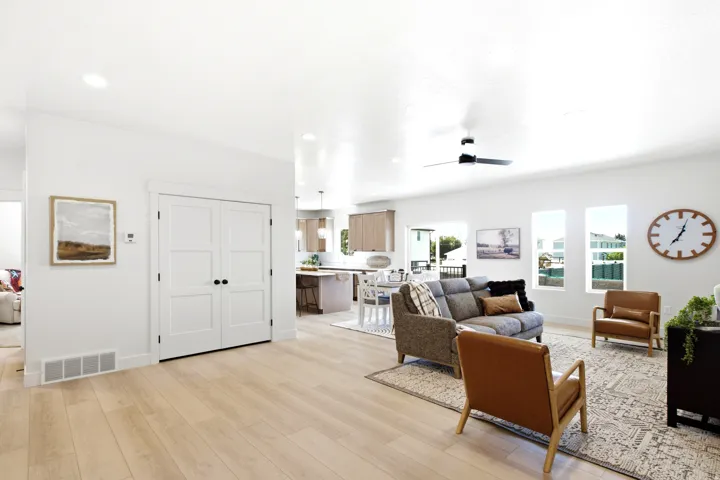 Light wood-finish flooring throughout, white walls, recessed lighting, and a ceiling fan
