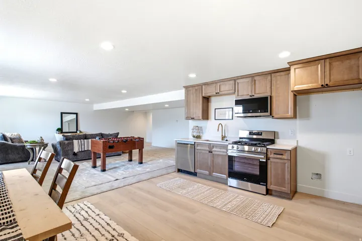 Full kitchen featuring stainless steel appliances, light wood-finish cabinetry, and a light-toned countertop