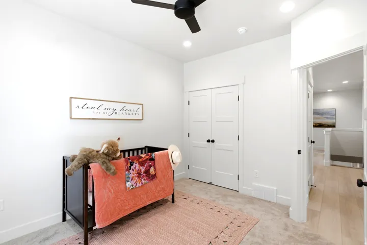 White walls, recessed lighting, and a black ceiling fan