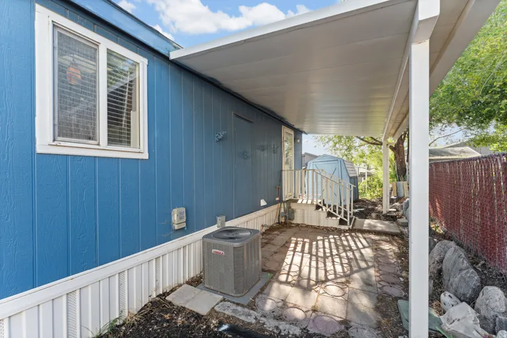 Covered patio space featuring a concrete slab and access to exterior stairs