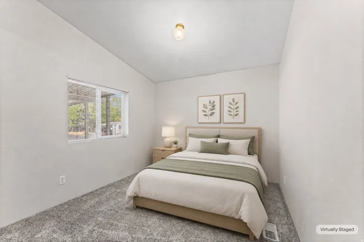 Soft gray carpeting, white painted walls, and a window with horizontal blinds
