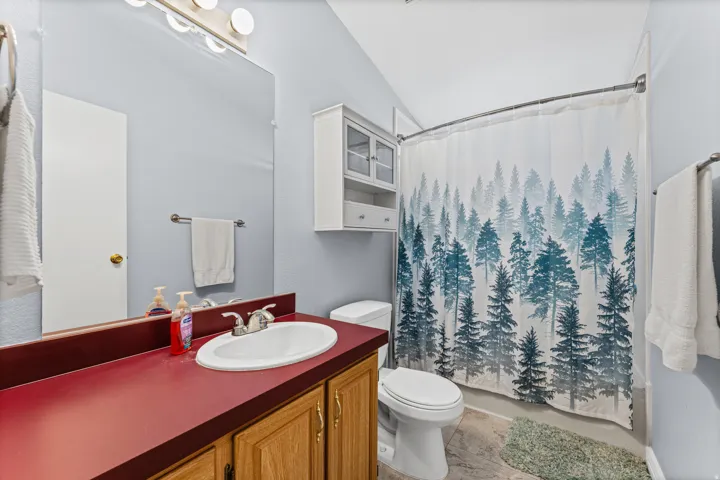 Vanity with an oval sink, chrome faucet, and red countertop