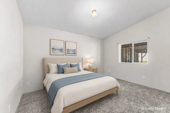 Carpeted flooring, vaulted ceiling, and a single window