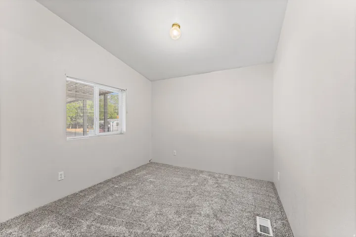 Neutral wall color with a window featuring blinds