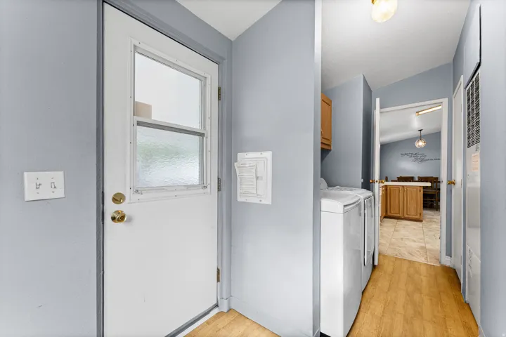 Utility area featuring wood-finish flooring and a built-in cabinet