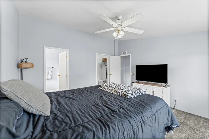 Ceiling fan with integrated lighting, light gray wall finishes, carpeted flooring, and white interior doors