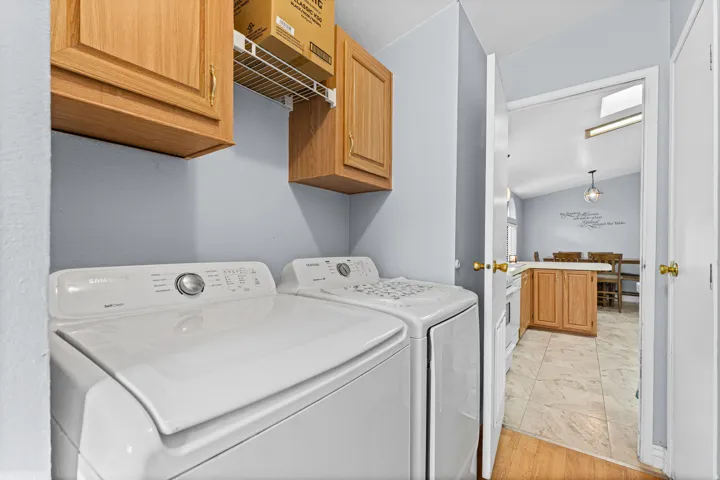 Laundry area with wood-finish cabinetry and overhead wire shelving