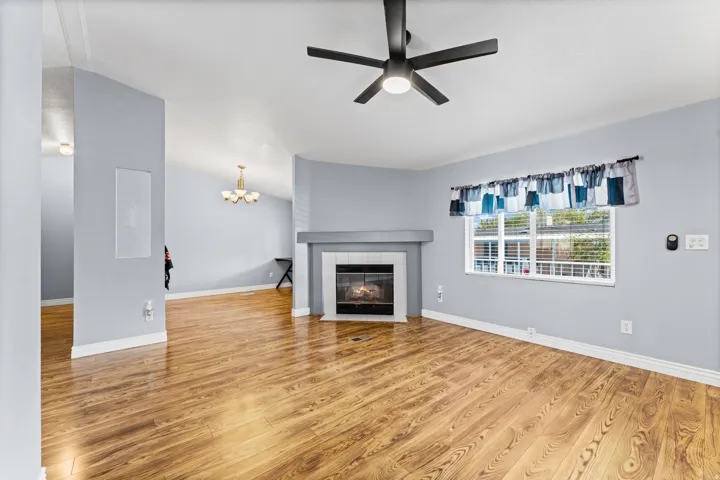 Wood-finish flooring, vaulted ceilings, and a built-in fireplace with a tiled surround