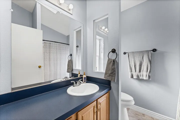 Vanity with a white oval sink and chrome faucet, set into a dark blue countertop