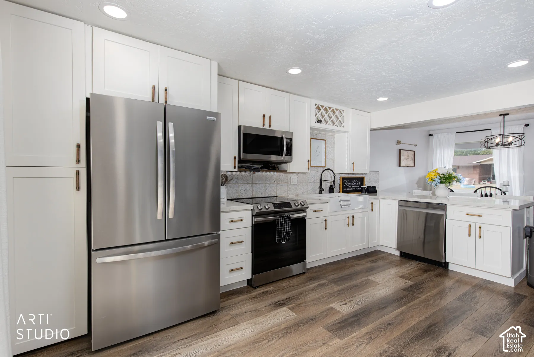 Kitchen featuring stainless steel appliances, white cabinetry, wood-finish flooring, white countertops, and recessed lighting