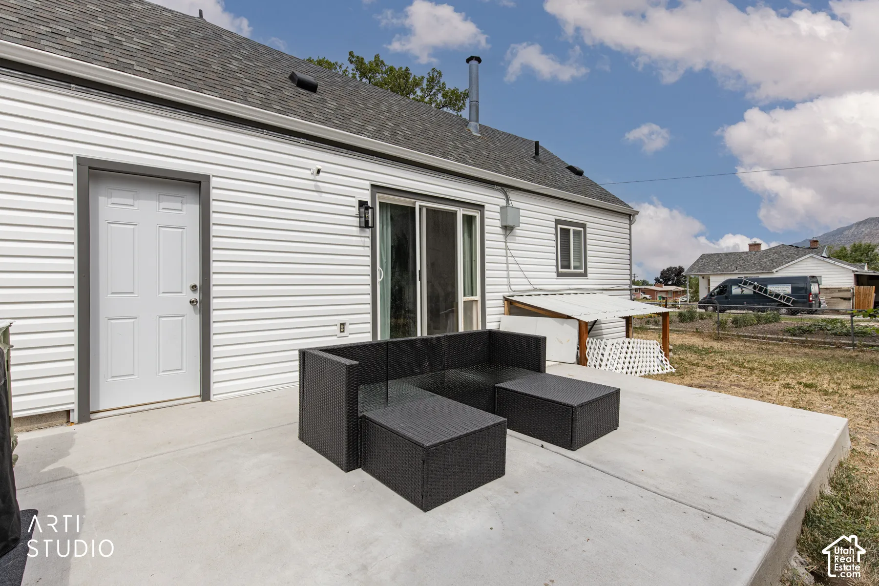 Expansive concrete patio with exterior door access and sliding glass doors