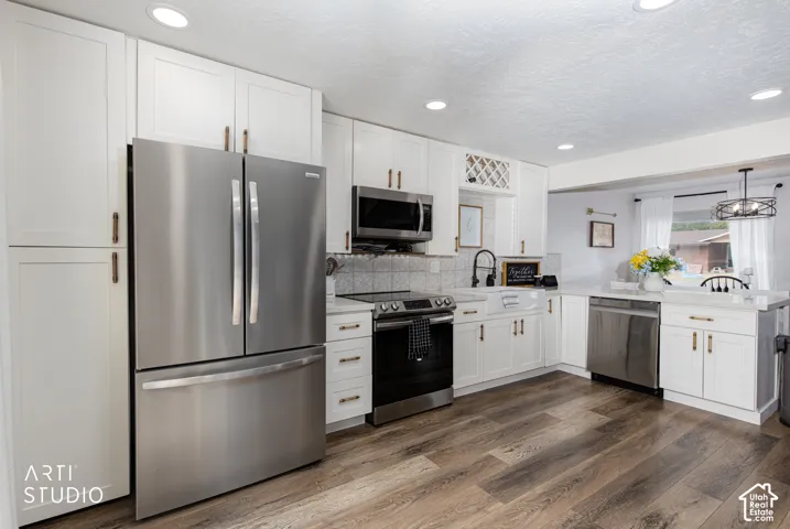 Kitchen featuring stainless steel appliances, white cabinetry, wood-finish flooring, white countertops, and recessed lighting