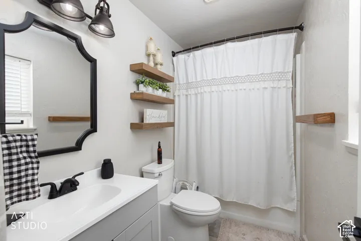 Vanity with matte black fixtures, framed mirror, and wood-finish floating shelves