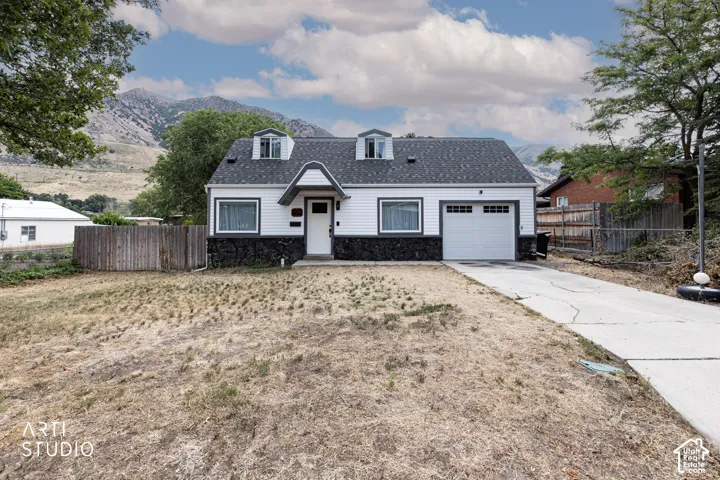 Charming residence featuring a freshly paved concrete driveway, two-car garage with overhead door, and a generous front-facing lot