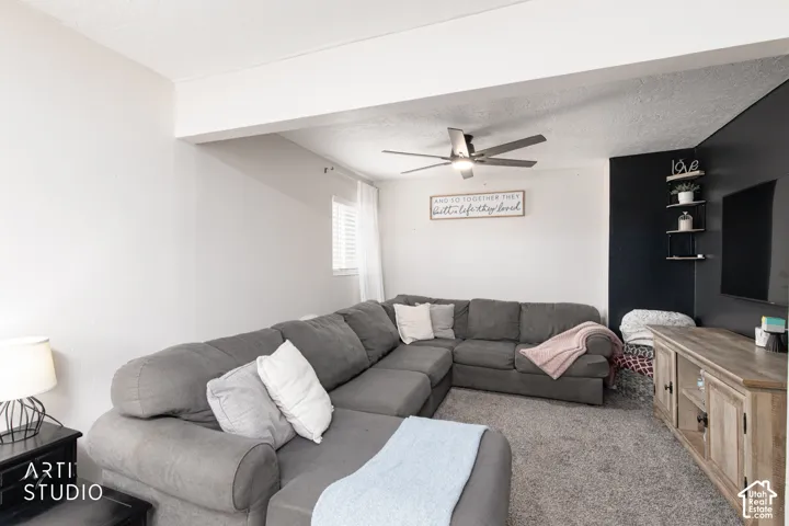 Spacious family room featuring a sectional seating arrangement, neutral carpet flooring, and abundant natural light from multiple windows