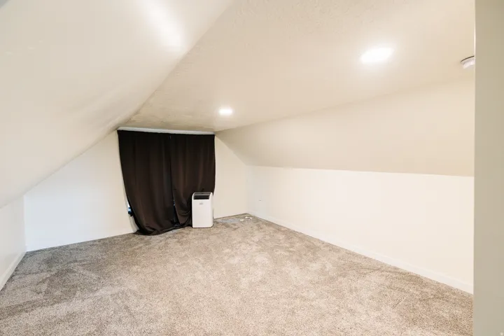 Vaulted ceiling room featuring recessed lighting and wall-to-wall carpeting