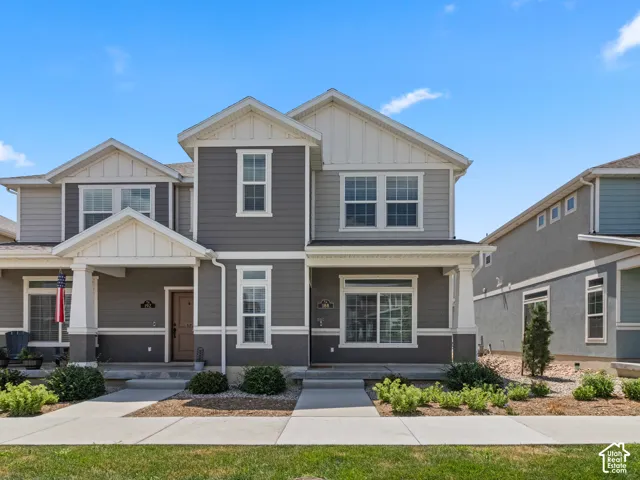 Two-story exterior with a covered porch entry, multi-pane windows, and a combination of siding and stucco finishes