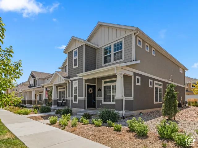 Exterior featuring a covered porch, mixed siding and stucco facade, white trim, and a concrete walkway