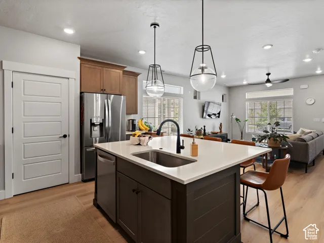 Open-concept kitchen with a large island, stainless steel appliances, and wood-finish flooring