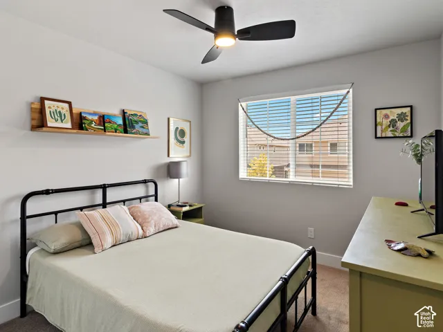 Recessed window with horizontal blinds, overhead ceiling fan with lighting, light-toned wall paint, and a built-in wooden wall shelf
