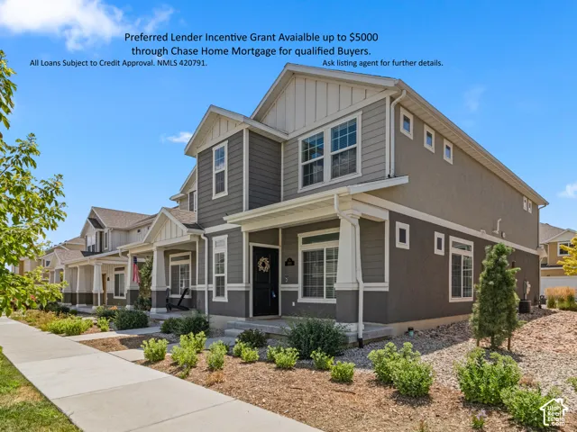 Two-story residence featuring a covered front porch, a combination of siding and stucco exterior, and multiple windows