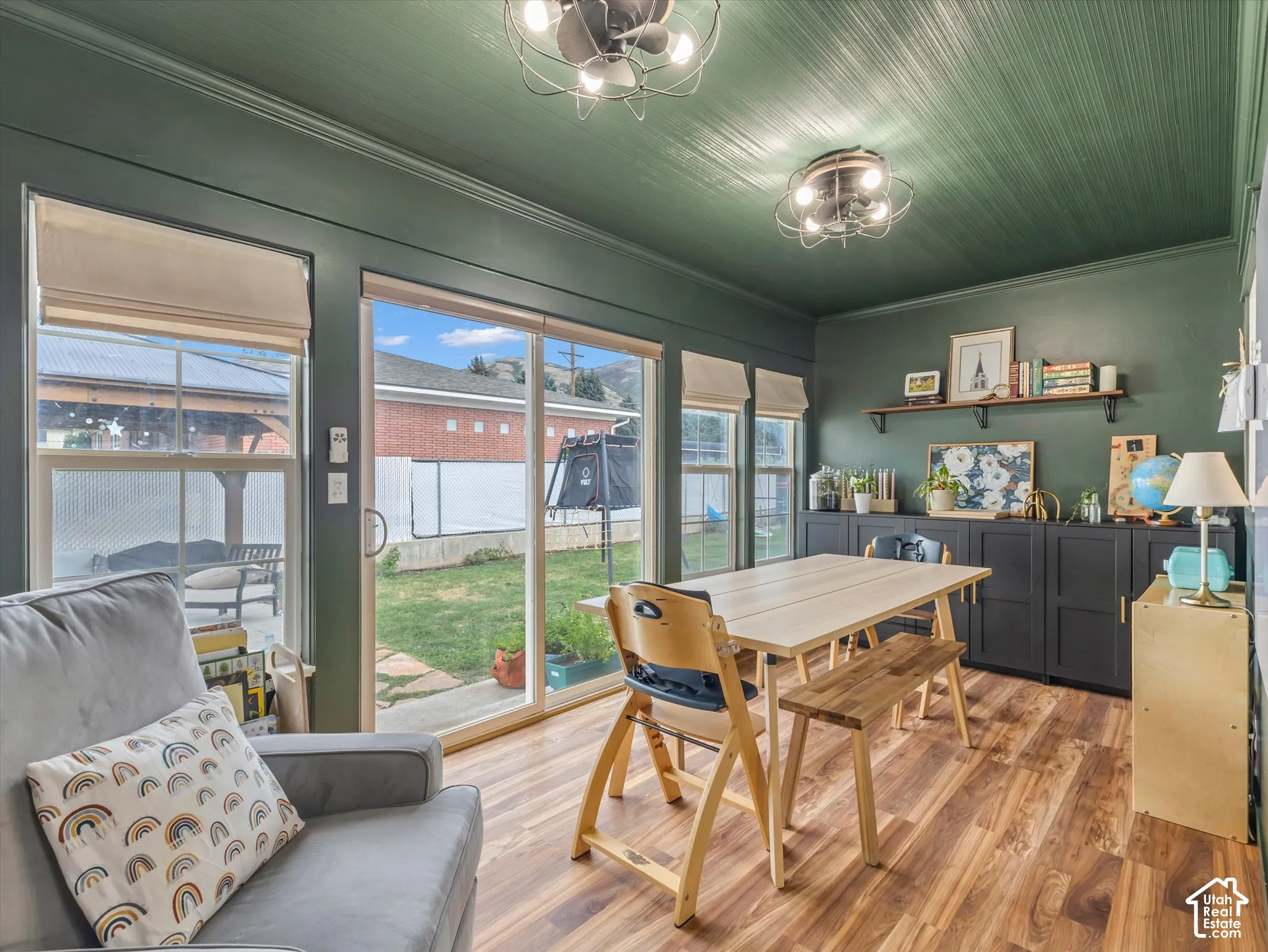Wood-finish flooring, built-in cabinetry, dual sliding glass doors, horizontal paneling on ceiling, and crown molding