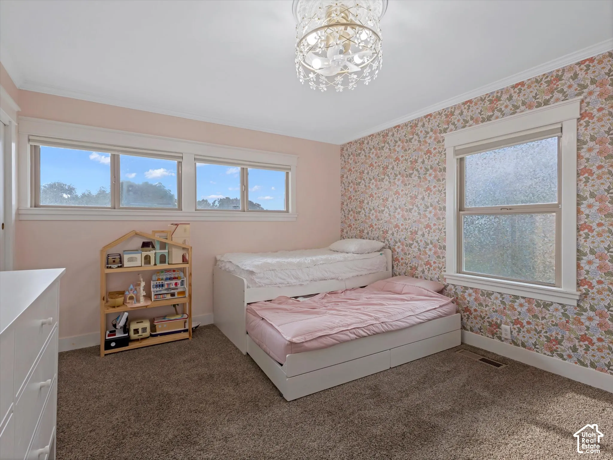 Textured wallcovering accent, multiple windows, plush carpet flooring, and a decorative ceiling fixture