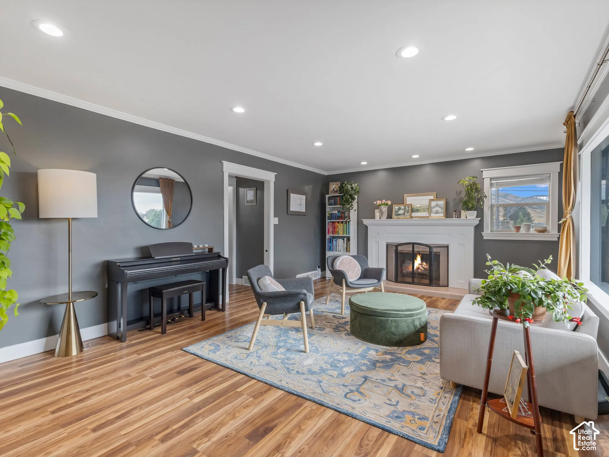 Recessed lighting, LVP flooring, and a white mantel fireplace with a dark firebox
