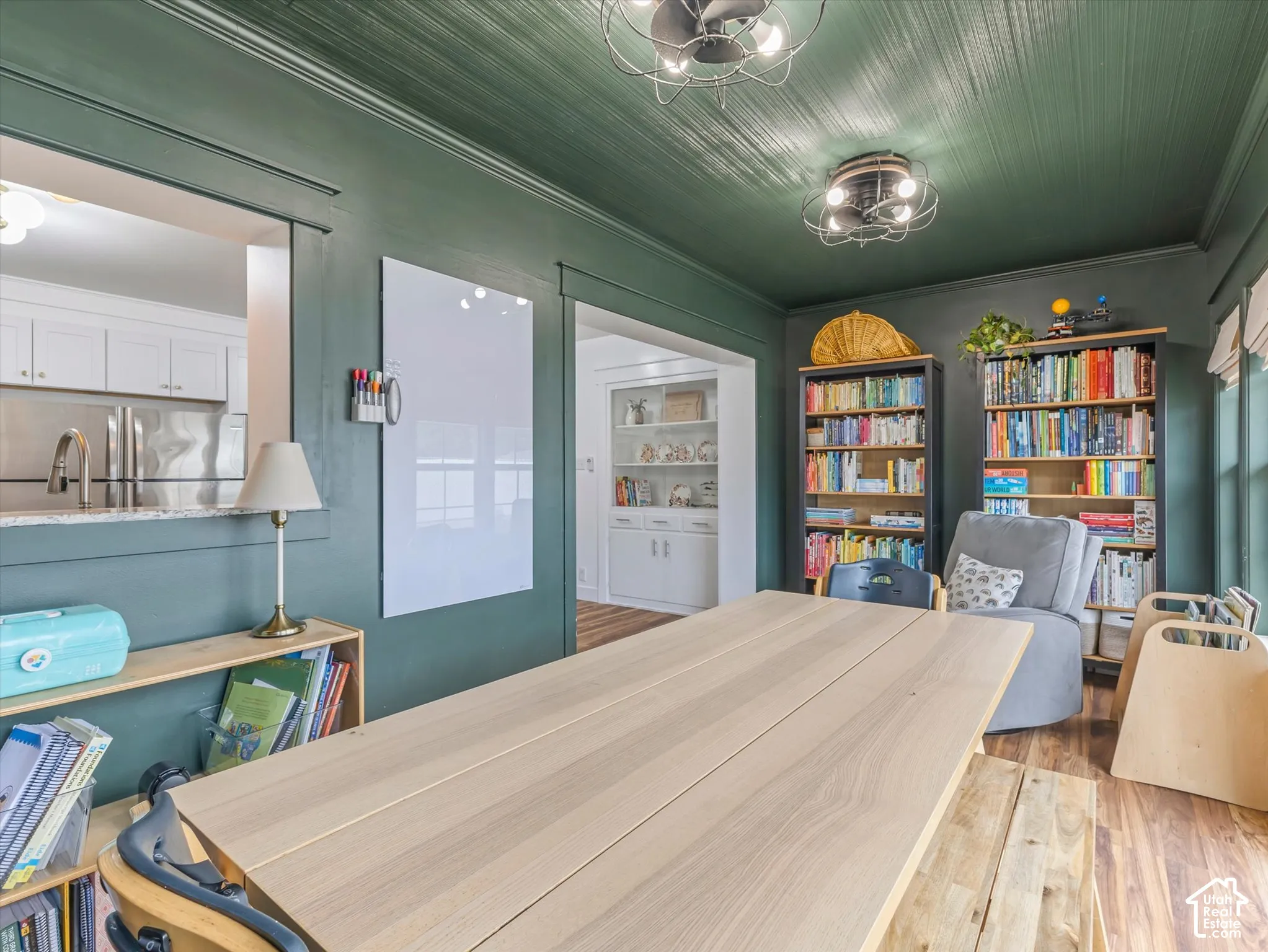 Recessed ceiling with wood-finish paneling, two ceiling-mounted light fixtures, built-in shelving, and wood-finish flooring
