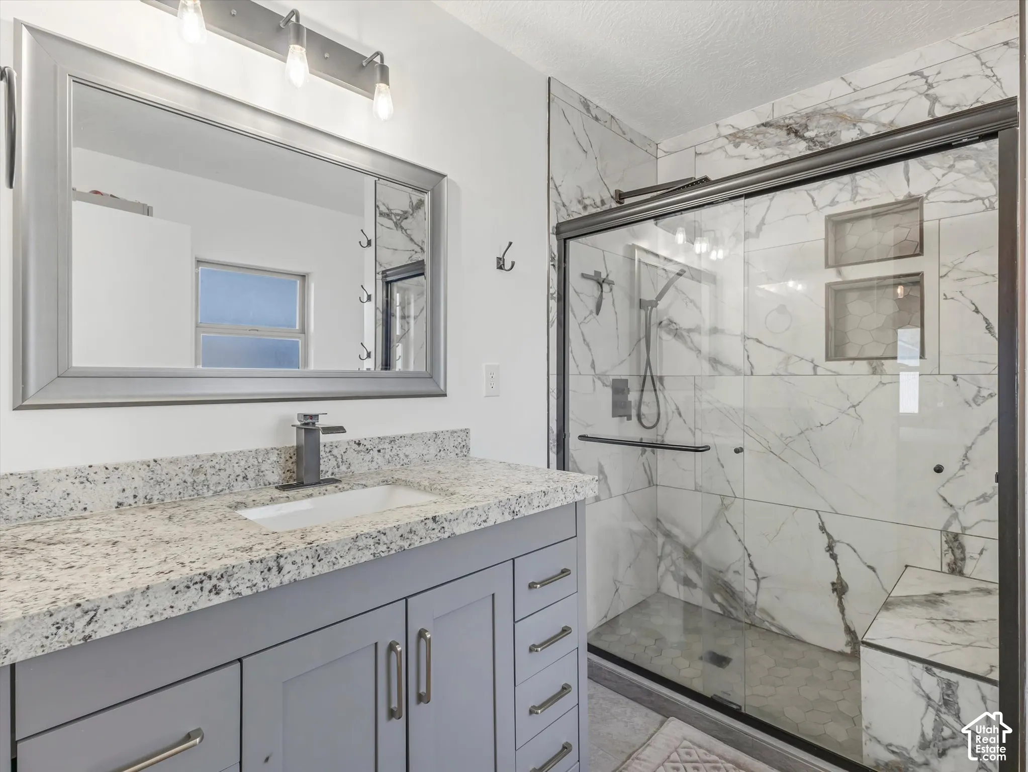 Vanity with a granite countertop, undermount sink, and contemporary faucet