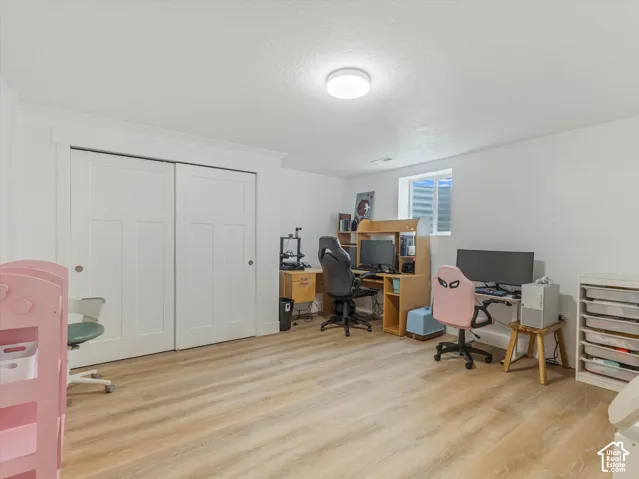 Recessed window, wood-finish flooring, white walls, flush mount lighting, and sliding panel doors