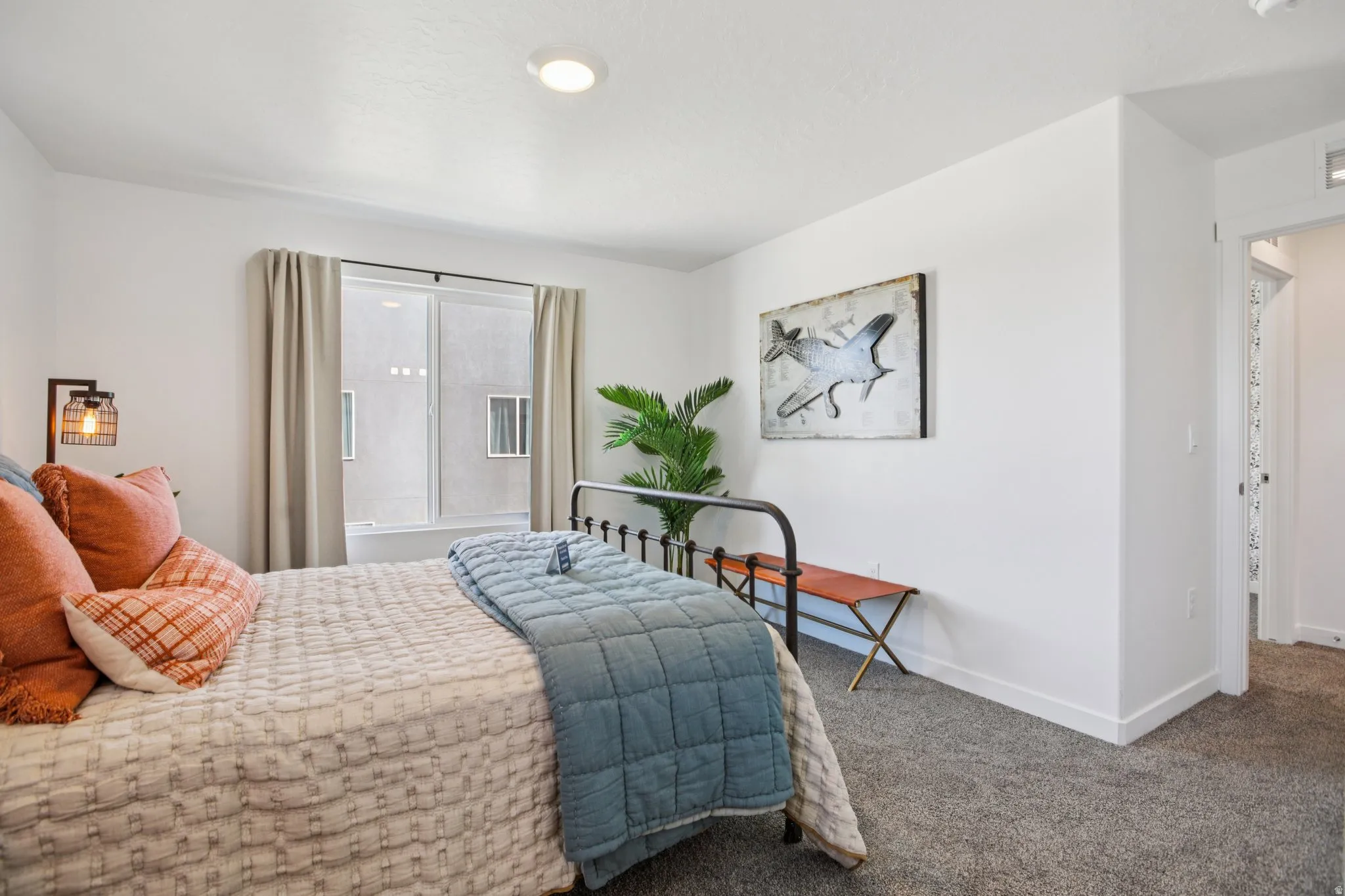 Carpeted bedroom with a sliding window, recessed ceiling lighting, and a doorway