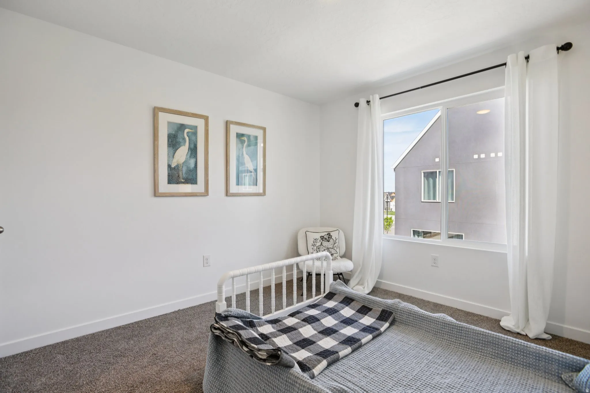 Carpeted room with a large window, white walls, and white trim